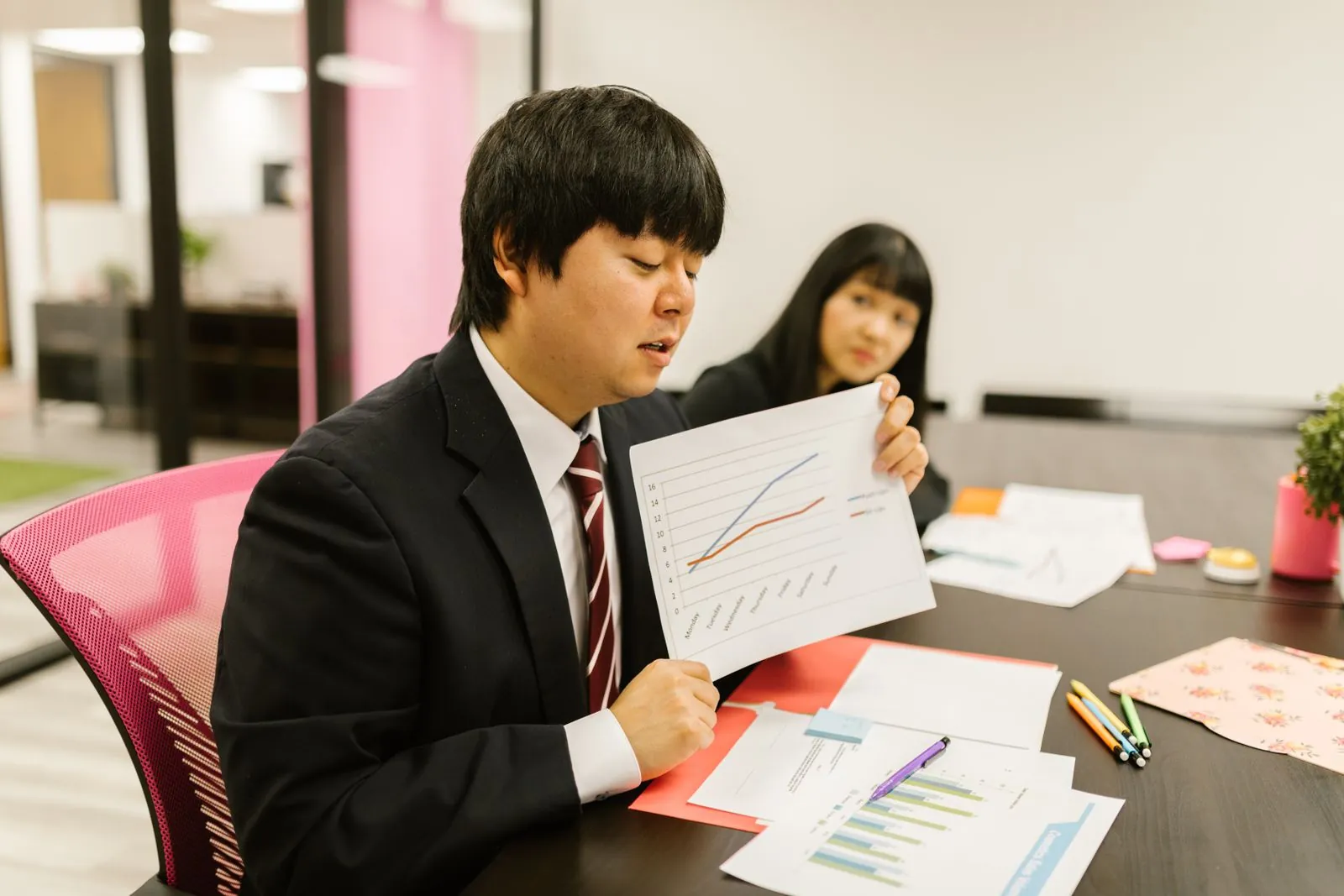 配信結果のグラフを示して説明している担当者