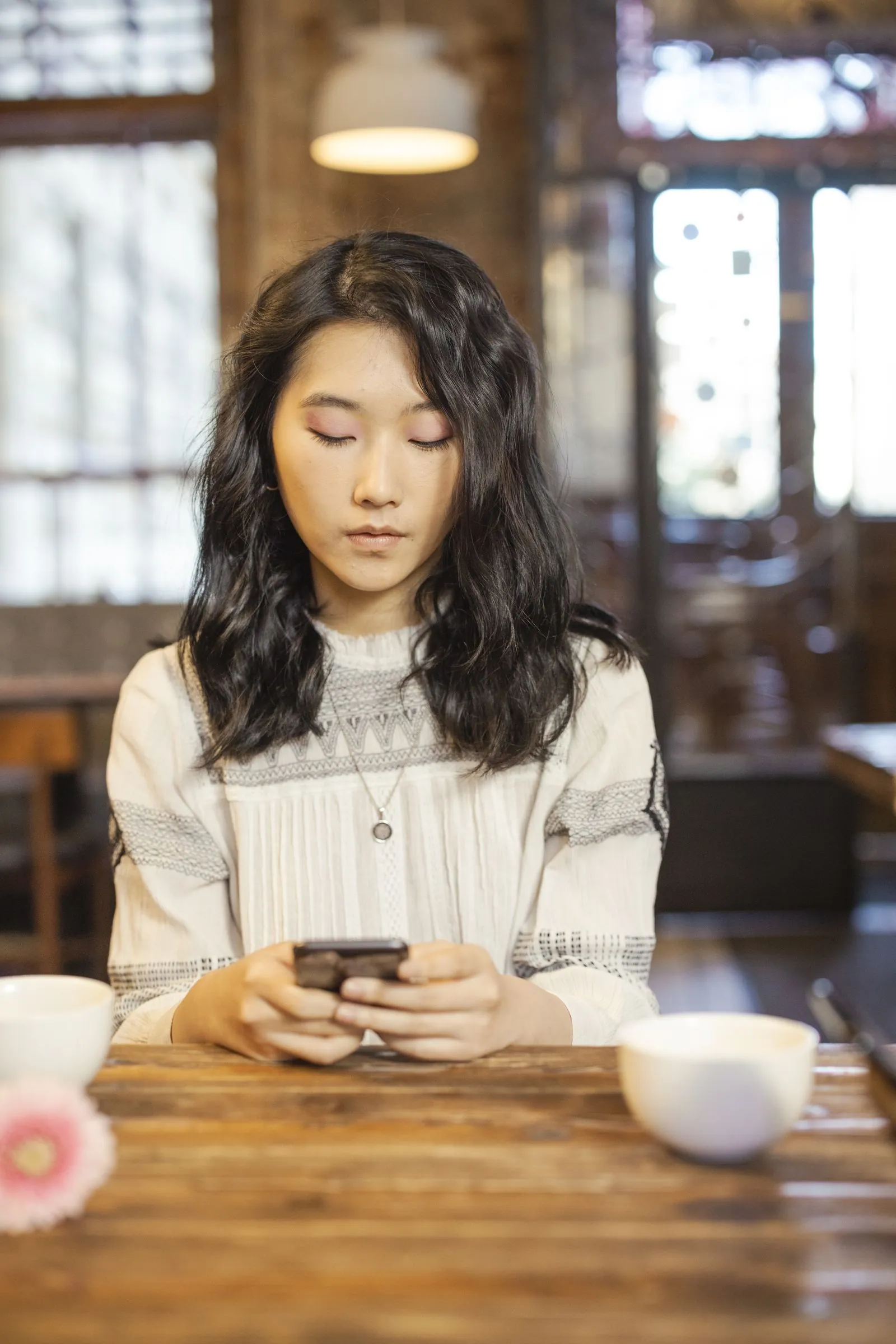 カフェでスマートフォンの Instagram を見ている女性